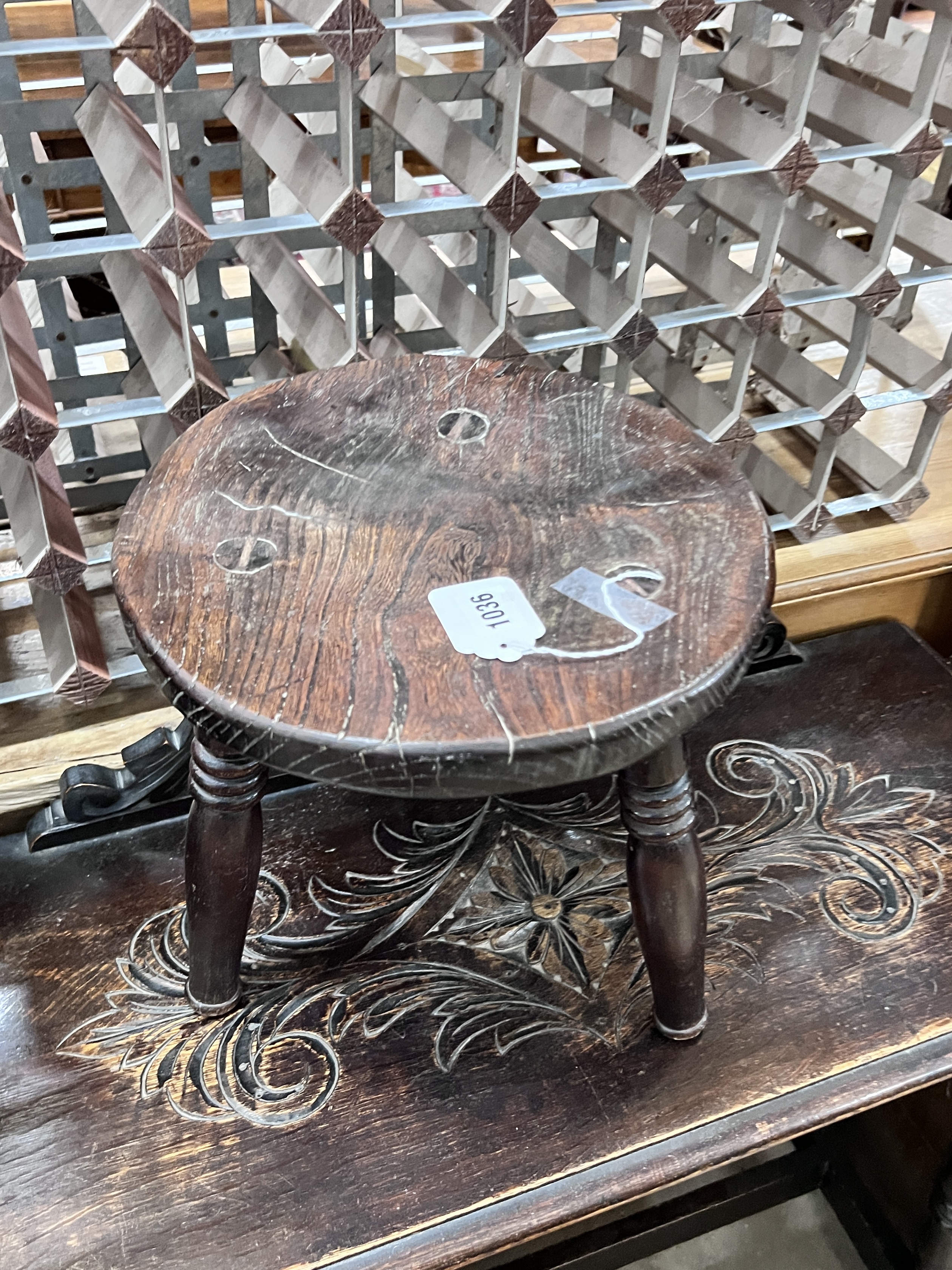 An early 20th century carved oak open bookcase, width 92cm, depth 26cm, height 114cm, together with a carved oak table and circular stool